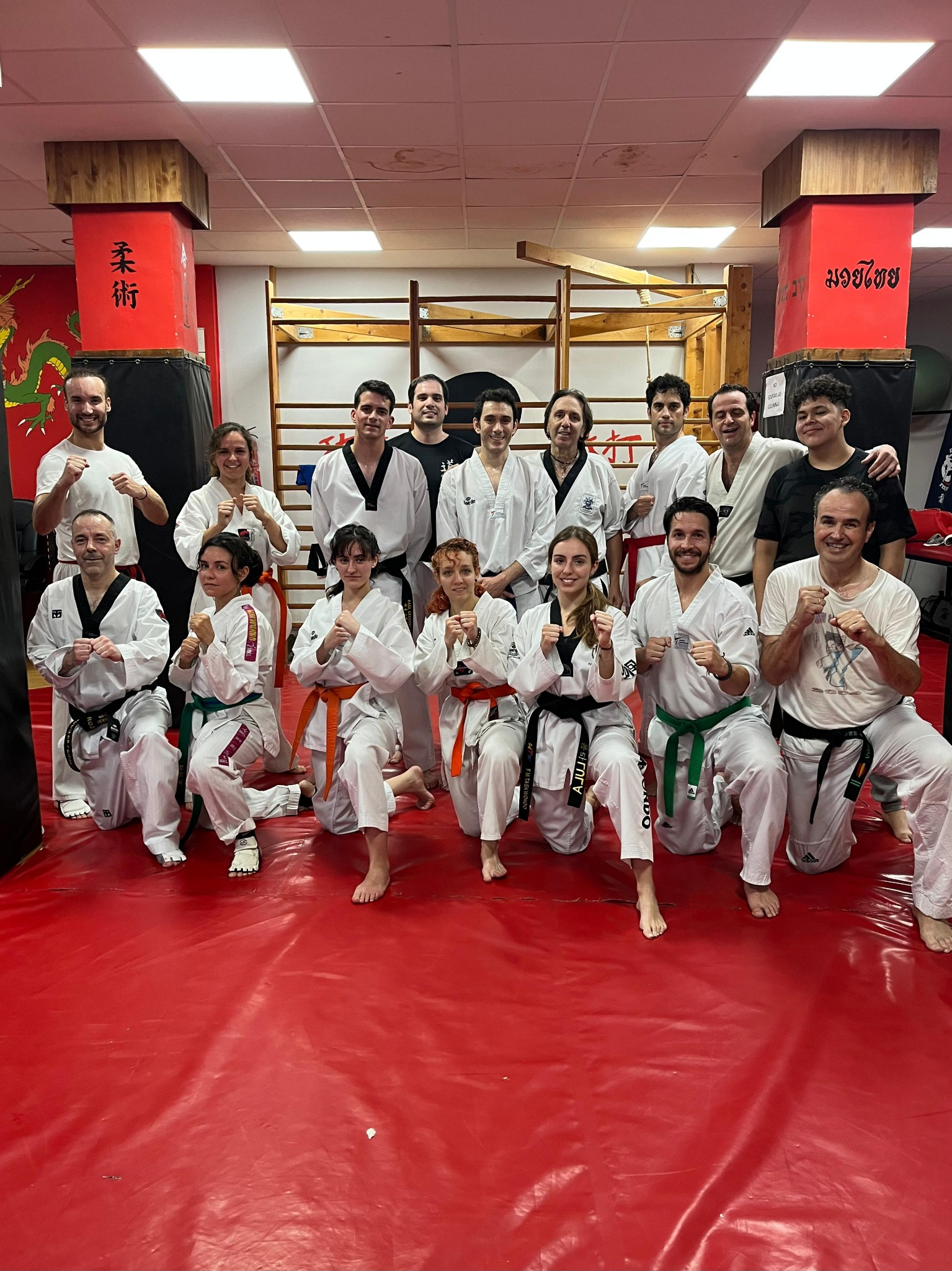 Grupo posando en el dojang sobre tatami rojo