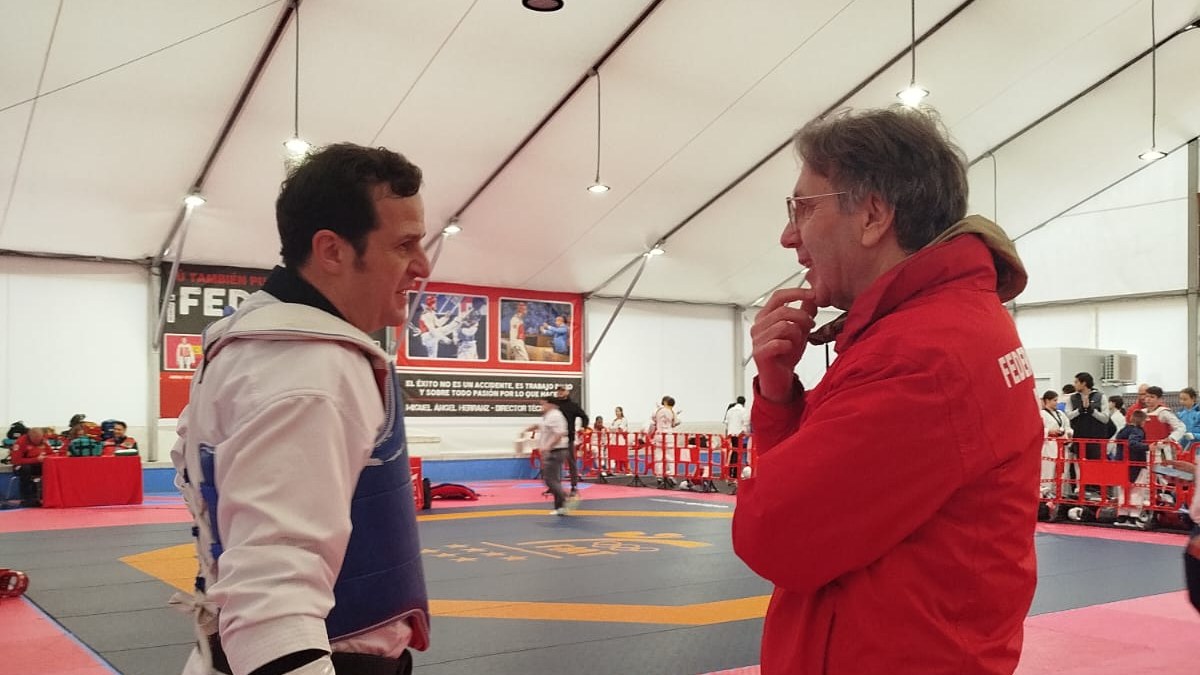 Competidor conversando con un entrenador durante una jornada de Taekwondo